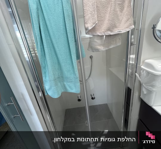 מקלחון עם מגבות תלויות על הדלת